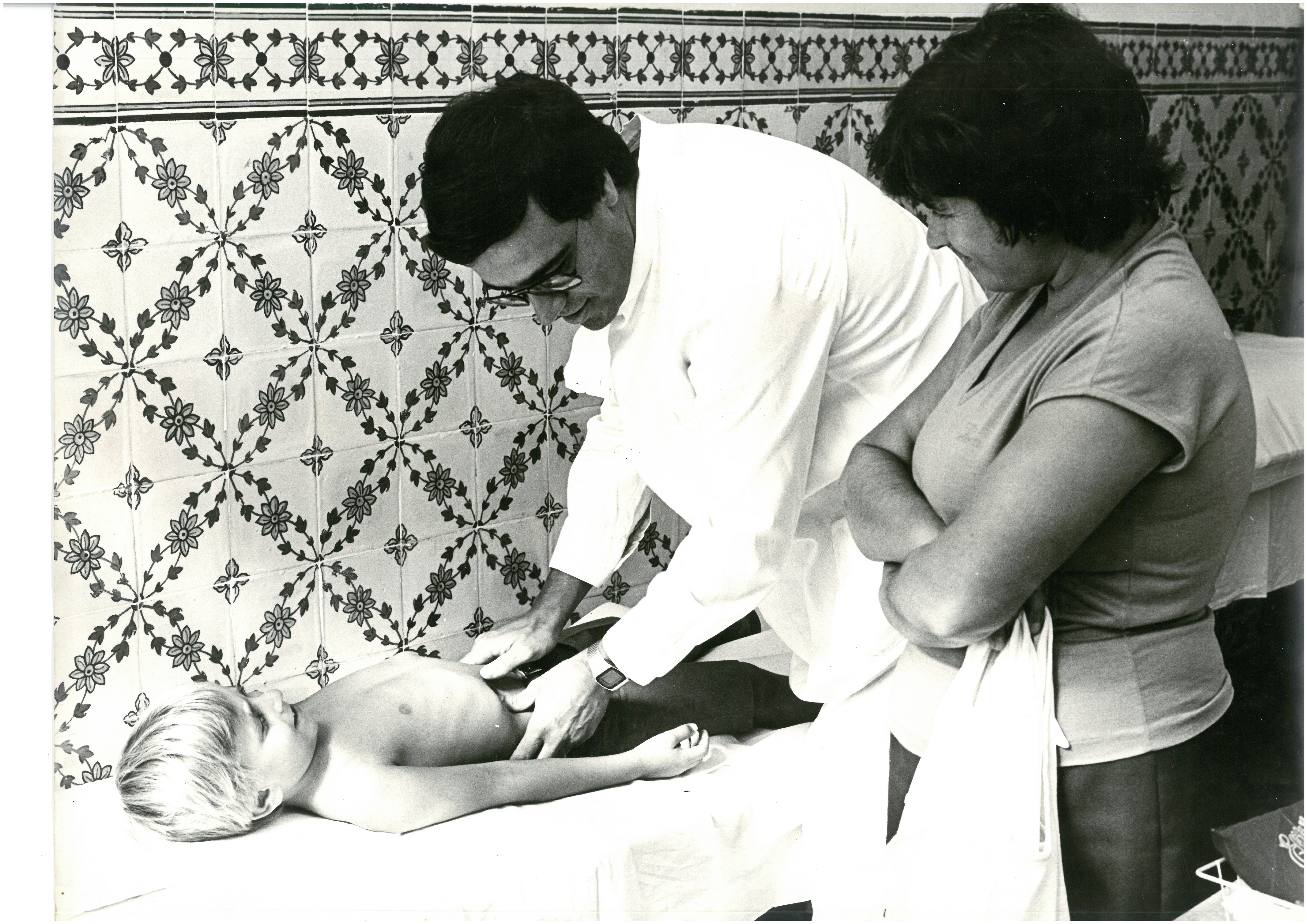 Médico no interior do consultório a atender uma criança, em 1980 (3)